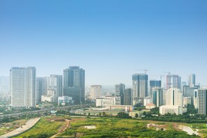 A cityscape with high-rise buildings, a highway, and green spaces. - Hanoi Cozy Home 2BR w SKY VIEW - Vinhomes Skylake (Hanoi)