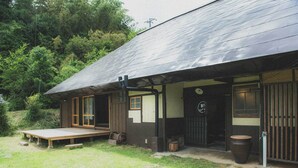 Eine rustikale Holzhütte mit Veranda und einer kleinen Sitzgelegenheit im Freien.