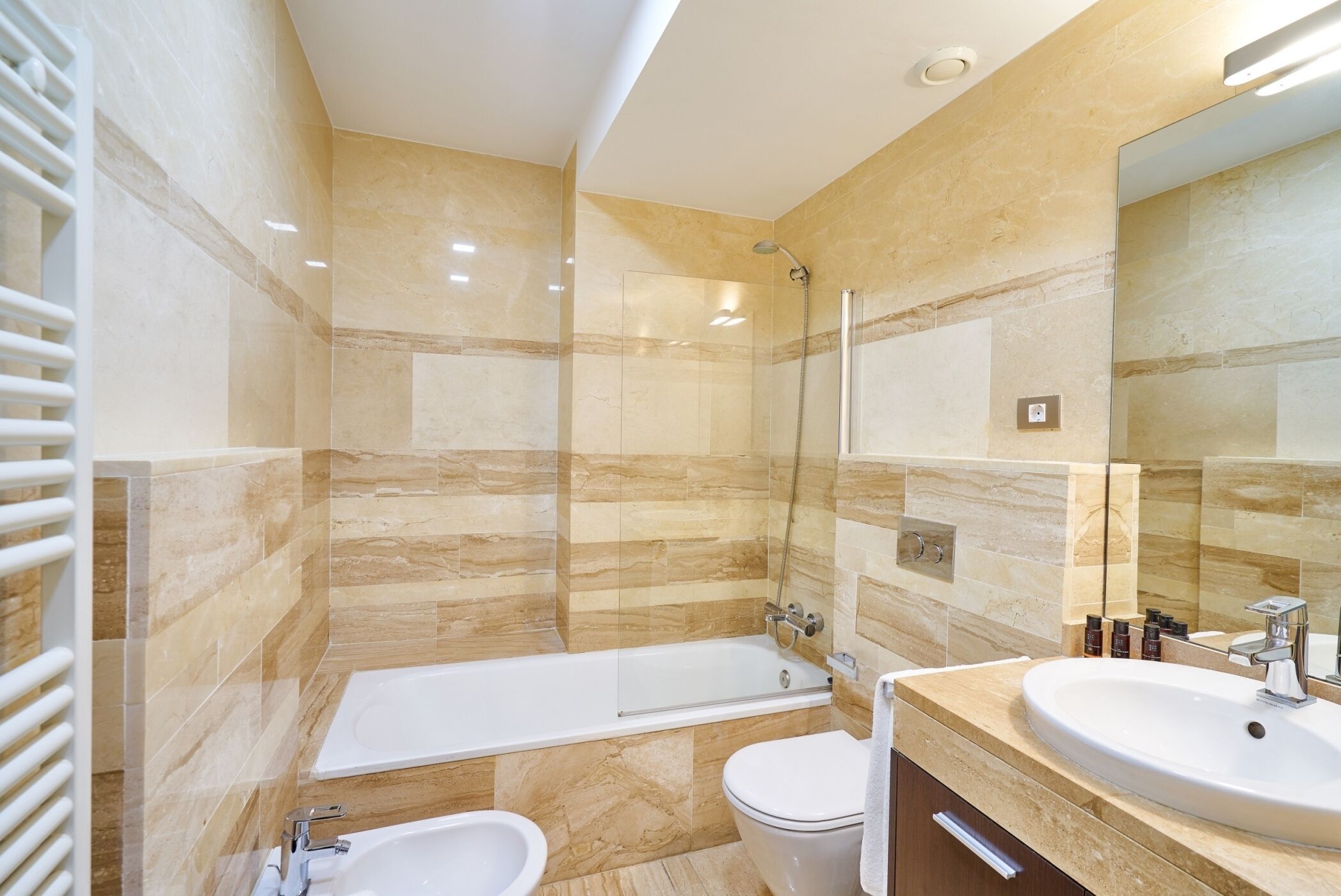 A modern bathroom with a bathtub, toilet, and sink.