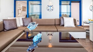 Una sala de estar moderna con un sofá marrón, una mesa de centro de cristal y una escultura decorativa de pez.