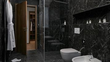 Une salle de bain moderne avec une douche à parois de verre, des toilettes et un lavabo.