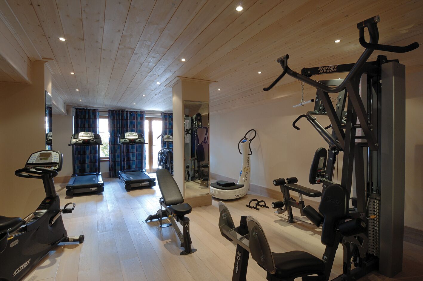 A gym with cardio machines, weightlifting equipment, and a treadmill.