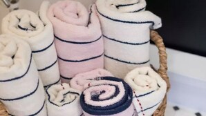 A basket filled with rolled towels in various colors and patterns. - Not Ninja Kyocera Dome 1 - 5th Floor Room (Osaka)