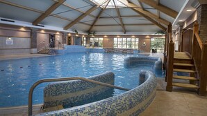 An indoor swimming pool with a tiled edge, wooden beams, and a staircase leading to an upper level. - Hotel Minella (Clonmel)