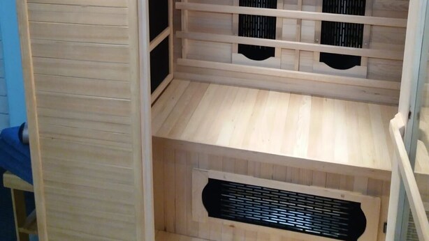 Un sauna équip é d’un panneau de commande, de bancs en bois et d’un système de ventilation.