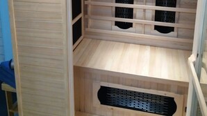 Ein Saunaraum mit Bedienfeld, Holzbänken und einem Lüftungssystem.