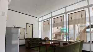 A room with a wooden floor, a sofa, a table, and a refrigerator. - Not Ninja Osaka Hirano 1 (Osaka)