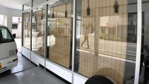 A modern building with large windows and a white van parked inside. - Not Ninja Osaka Hirano 1 (Osaka)