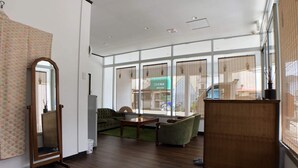 A spacious room with a large window, a wooden floor, a green sofa, a wooden table, and a mirror. - Not Ninja Osaka Hirano 1 (Osaka)