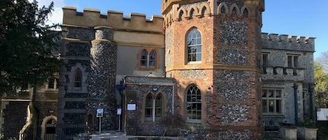 A castle-like building with a central tower, arched windows, and stone walls.