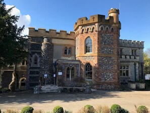 A castle-like building with a central tower, arched windows, and stone walls.