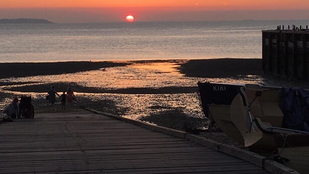 A wooden pier leading to a beach with a sunset in the background. - 59a Whitstable - 1 Bedroom Flat, Balcony & Parking (Whitstable)