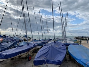 A row of sailboats covered with tarps, docked at a pier with a cloudy sky above. - 59a Whitstable - 1 Bedroom Flat With Balcony (Whitstable)