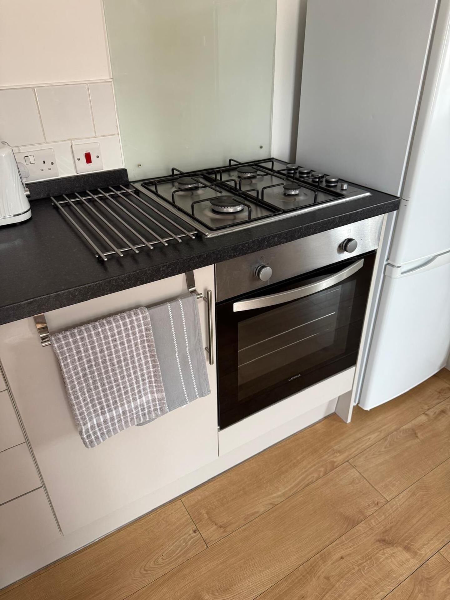 A kitchen with a gas stove, oven, and a coffee maker.