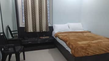 Un dormitorio con una cama, un escritorio y una silla.