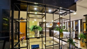 Un moderno vestíbulo de hotel con una pared de vidrio, plantas en macetas y un acuario.