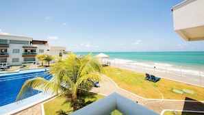 Un hôtel doté d’une piscine, offrant une vue sur la plage et disposant d’un espace clos avec des chaises longues.