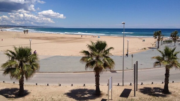 A beach with palm trees, a clear sky, and the ocean. - Comfortable apartment with pool and garden. (Torredembarra)