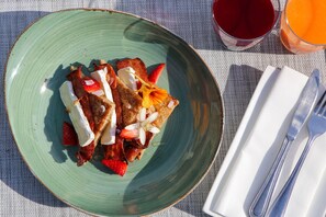 A plate of food with strawberries and a drink on a table.