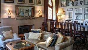 A cozy living room with a fireplace, comfortable seating, and a dining area.