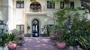 A courtyard with a reception sign, two benches, and potted plants.