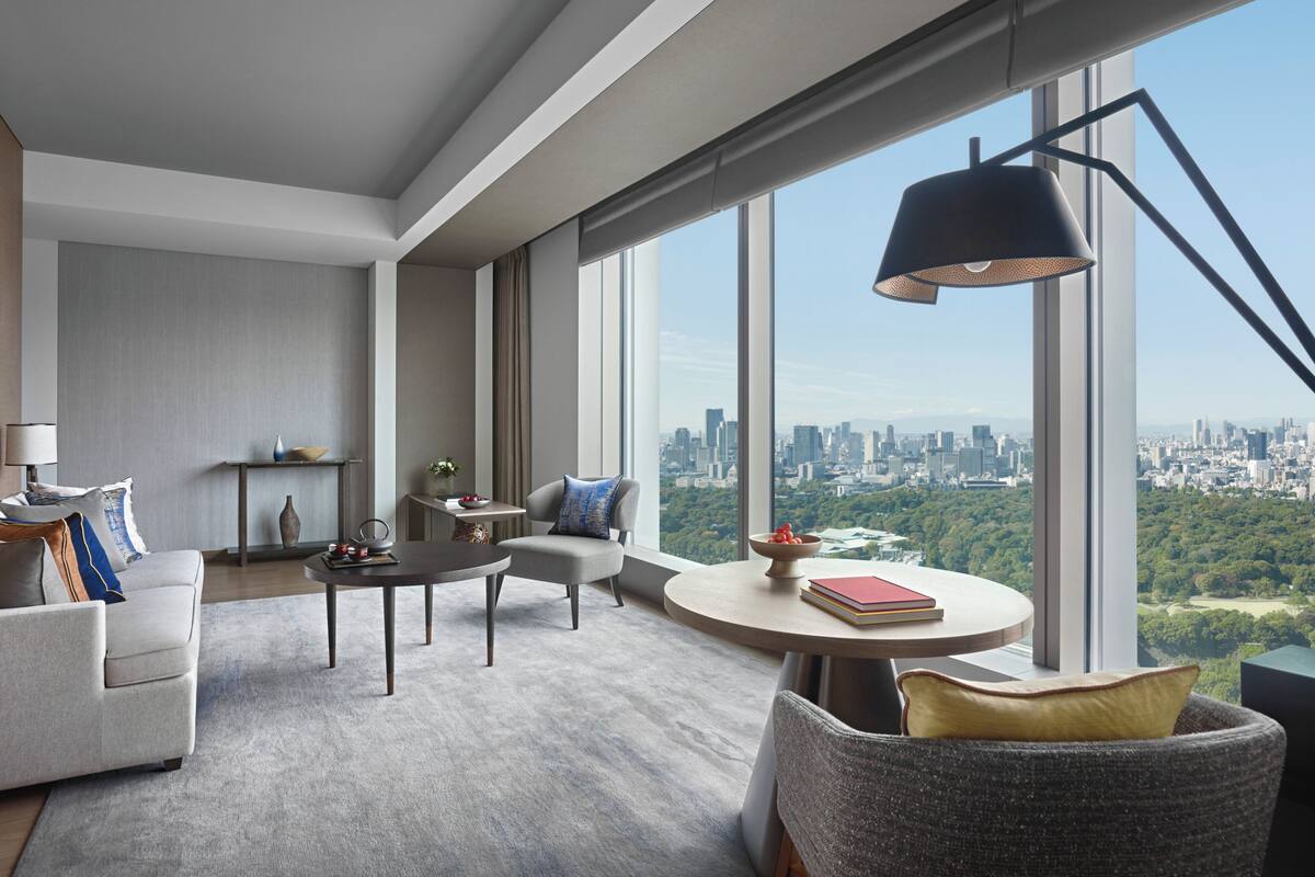 A modern living room with a city view, a round table, and a comfortable seating area.