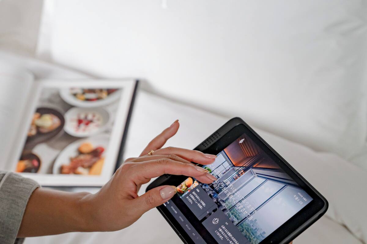 A person holding a tablet displaying a cityscape.