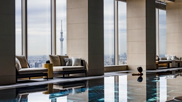 A modern hotel room with a large window, a pool, and a view of a tower. - Four Seasons Hotel Tokyo at Otemachi (Tokyo)