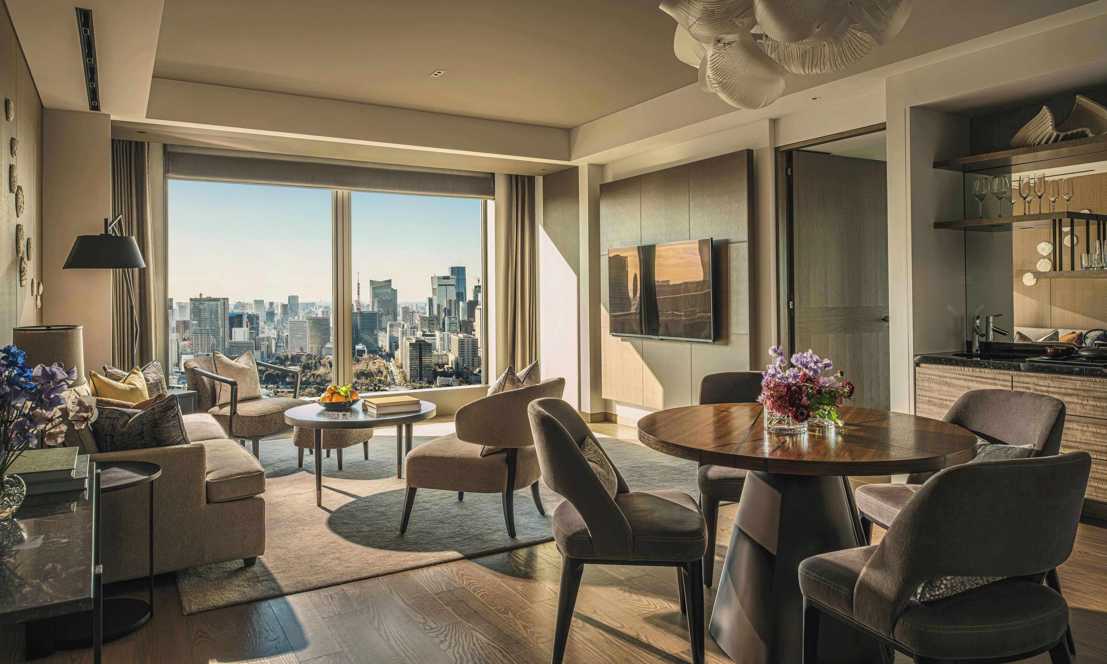 Una sala de estar moderna con vista a la ciudad, un comedor y una cocina.