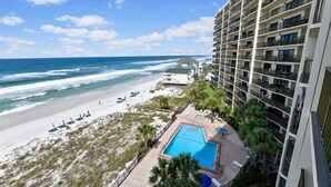 A beachfront hotel with a swimming pool, beach chairs, and a view of the ocean. - Rest Ashored Commodore 1303-Beachfront Master-Rest Assured, You'll Love It Here! (Panama City Beach)