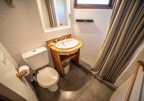 Un baño con inodoro, lavamanos y ducha.