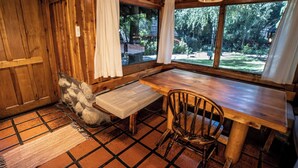 Un interior rústico de madera con un banco, una mesa y una silla.