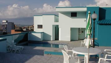 Una piscina al aire libre, sillones reclinables de piscina