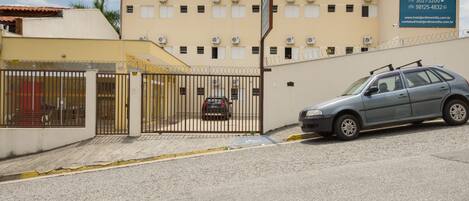 A gated entrance to a building with a sign for Hotel Jardim Emilia.