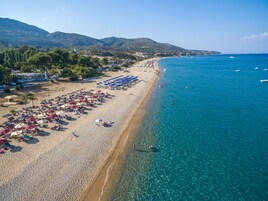 Una playa cerca, sillas reclinables de playa, sombrillas