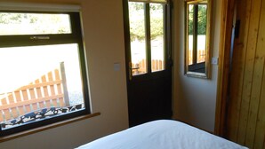 A bedroom with a bed, a window, and a door. - Birchdale House B&B (Greenan)