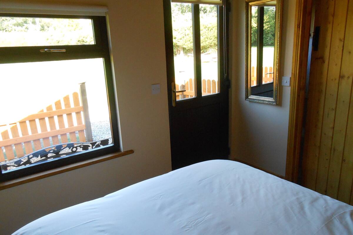Ein Schlafzimmer mit Bett, Fenster und Tür.