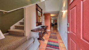 A staircase with carpeted steps leading to a landing with a wooden bench and a mirror. - Stunning Moab townhome on the golf course! (Moab)
