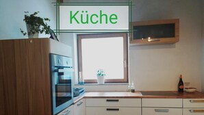 A kitchen with white cabinets, a window, and a sign that reads "Küche". - Apartment #1 in Haus Sophia with a unique view (DG) (Oberperfuss)