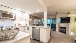 A modern kitchen with white cabinetry, stainless steel appliances, and a central island.