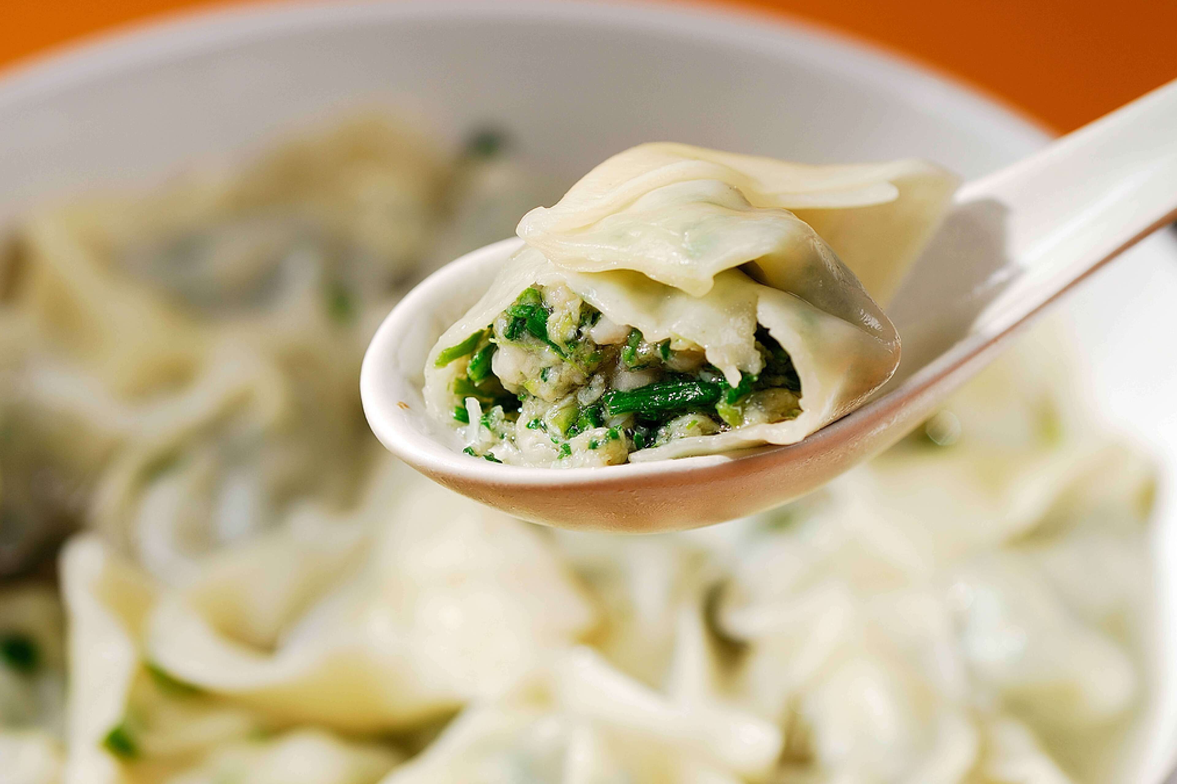 Een portie dumplings met een groene vulling van groenten.
