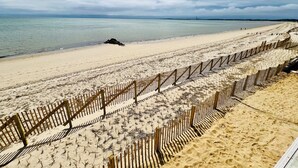 Une plage avec une clôture en bois et un ciel dégagé.