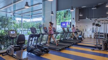 A gym with treadmills, exercise bikes, and weight machines.