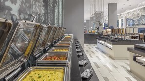 A buffet with various food options, a counter with plates, and a modern interior design. - Holiday Inn Express Kota Kinabalu City Centre by IHG (Kota Kinabalu)
