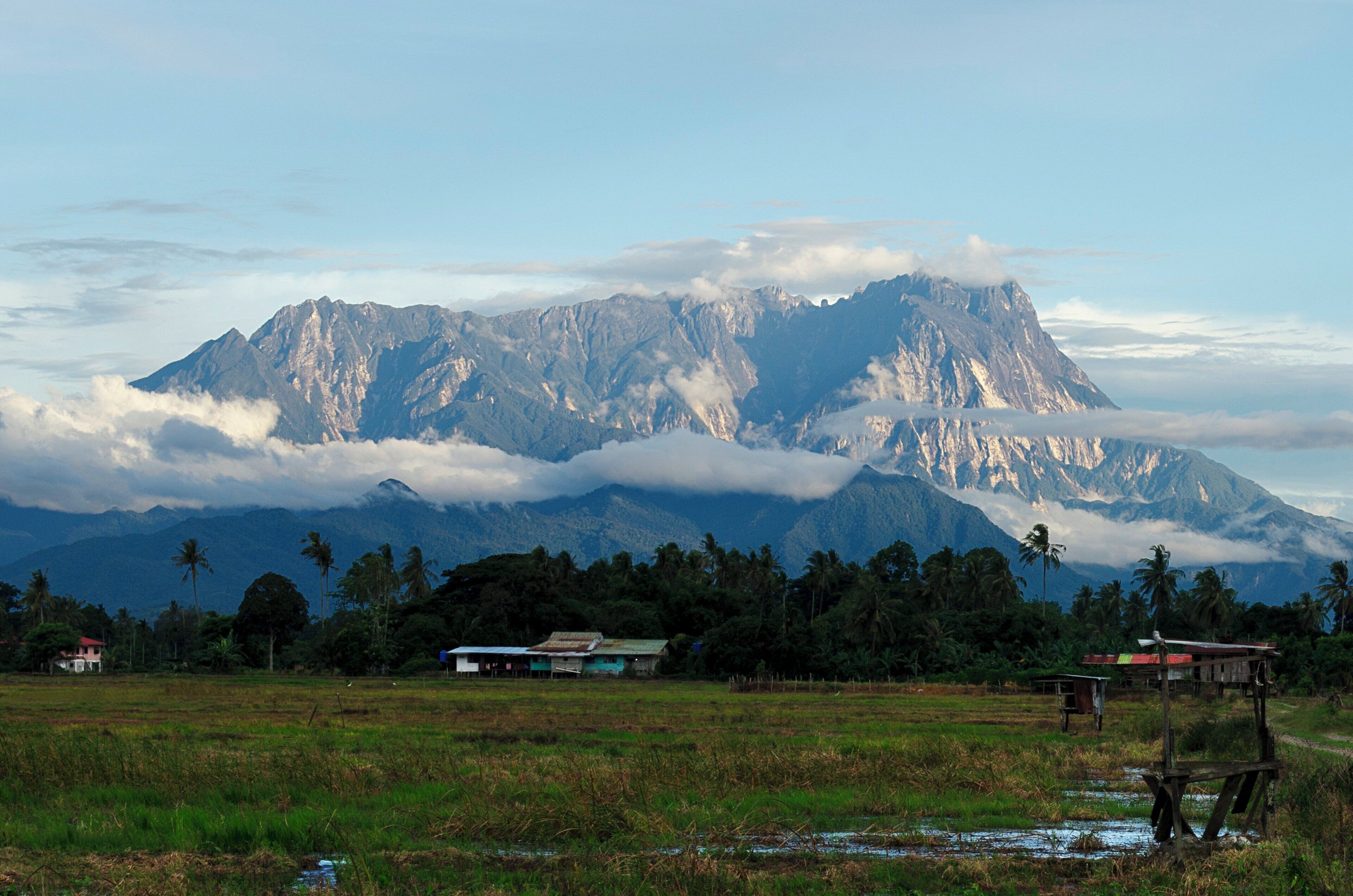 Un paysage de montagne avec une maison au premier plan.