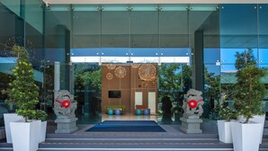A modern building entrance with glass doors, a blue carpet, and two lion statues. - Holiday Inn Express Kota Kinabalu City Centre by IHG (Kota Kinabalu)