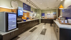 A modern kitchen with a digital menu display, a fruit bowl, and a breakfast bar. - Holiday Inn Express & Suites Brunswick - Harpers Ferry Area by IHG (Knoxville)