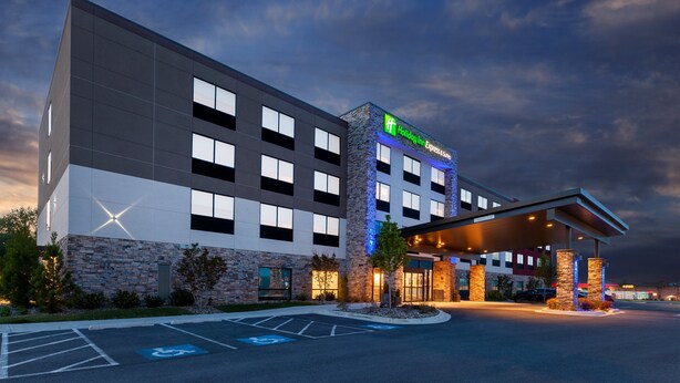 A Holiday Inn Express hotel with a modern design, featuring a stone facade, multiple windows, and a covered entrance. - Holiday Inn Express & Suites Brunswick - Harpers Ferry Area by IHG (Knoxville)