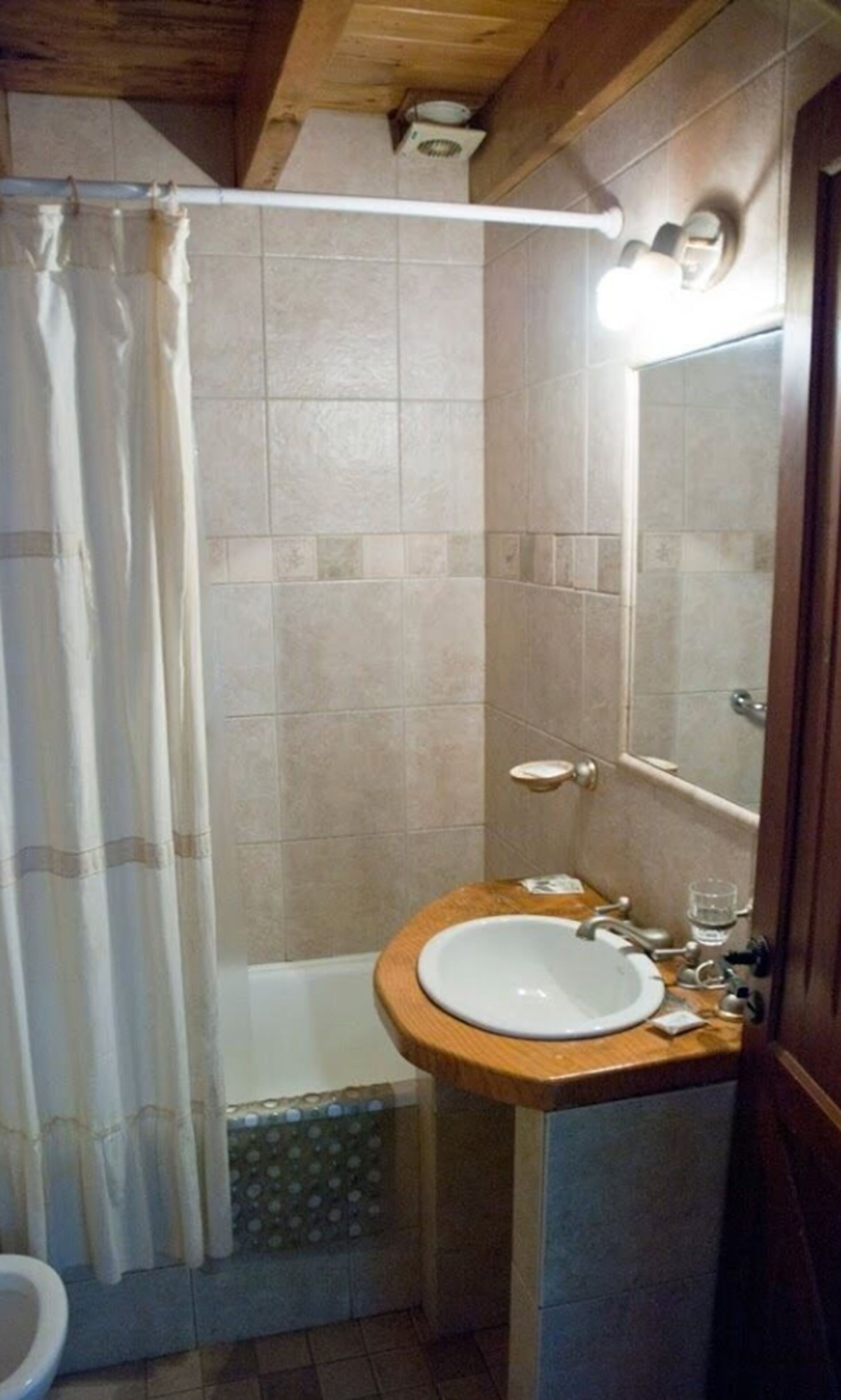 A bathroom with a shower, a toilet, and a sink.
