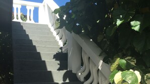A staircase with a white balustrade and a view of a building in the background.